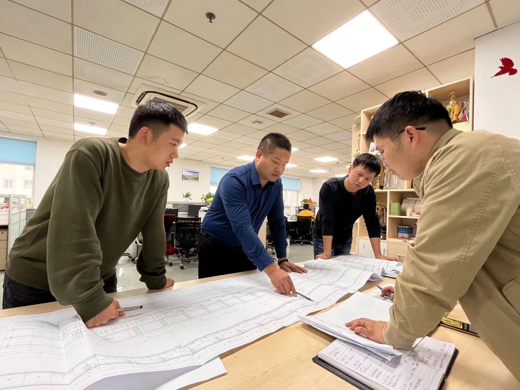 徐斌（左二）和同事在讨论设计方案。2022年10月摄于中铁第一勘察设计院。