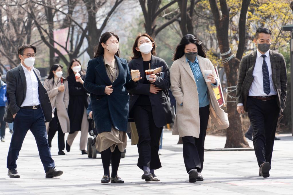 2022年3月16日，人们走在韩国首尔街头。新华社发（李相浩摄）