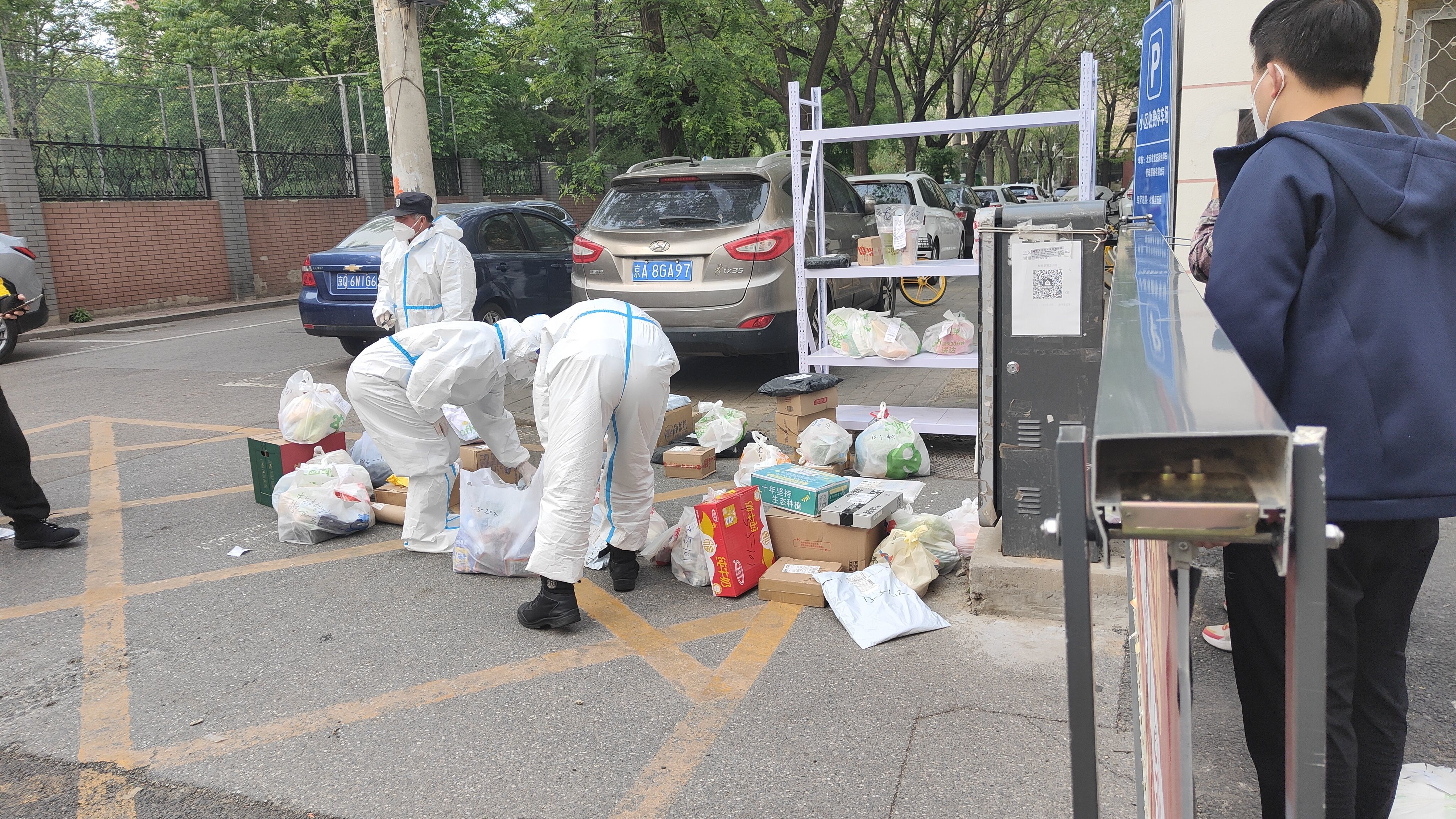 ▲4月29日,松榆里社区松五小区门口,志愿者们正帮居民们传递外卖和快递包裹。 新京报记者 刘瑞明 摄