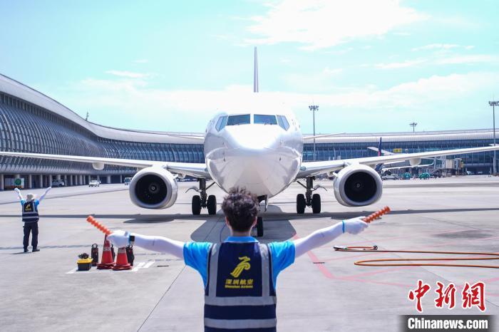 图为机务人员引导飞机停靠。 陈冠言 摄