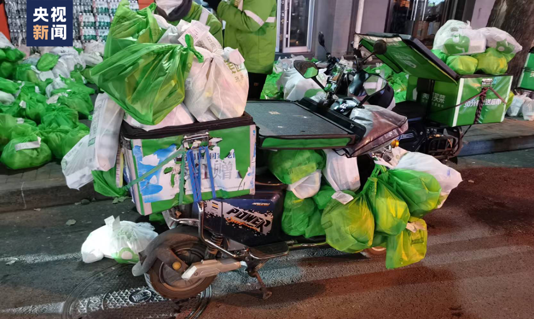 △站点前，一位骑手的电动车上挂满了物品。