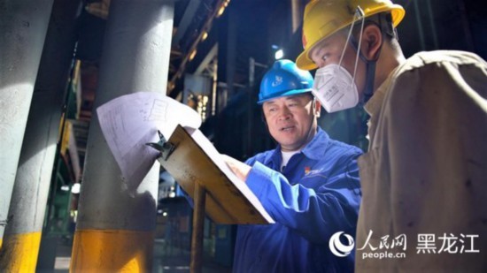 全国劳动模范、中国一重集团有限公司首席技能大师刘伯鸣（左）。 人民网 苏靖刚摄