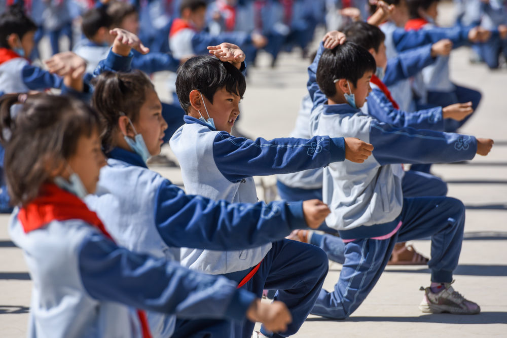 在新疆阿克苏地区乌什县依麻木镇国家通用语言小学，学生们在做课间操（2022年6月8日摄）。新华社记者 丁磊 摄