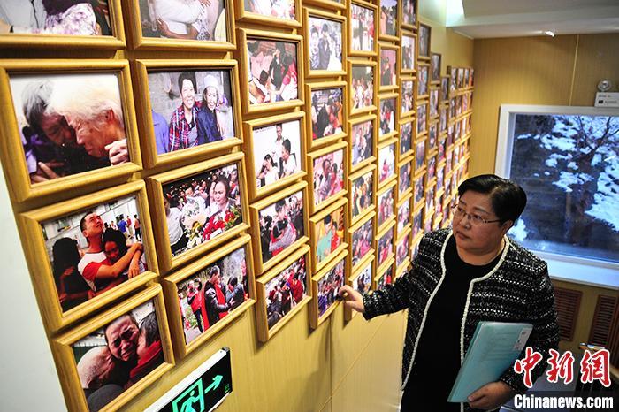 2月21日，吉林通化，全国人大代表张宝艳面对寻亲照片墙回顾多年打拐经历。中新社发 高龙安 摄