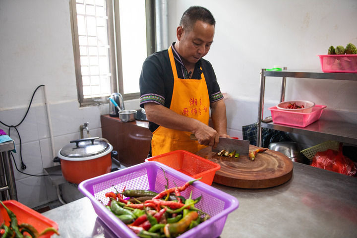 2020年9月17日，在汝城县沙洲瑶族村，朱小红在自家开的农家乐厨房里切菜。新华社记者 陈思汗 摄