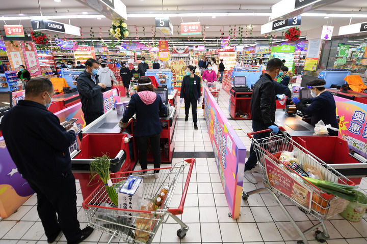 日,在西宁大十字百货商店有限公司广场店,市民选购生活物资后排队结账