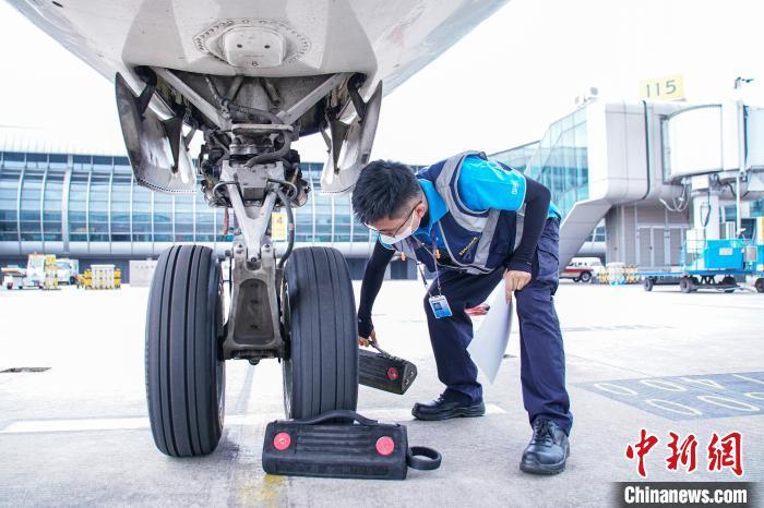 图为航线维护工程师摆放轮挡。 陈冠言 摄