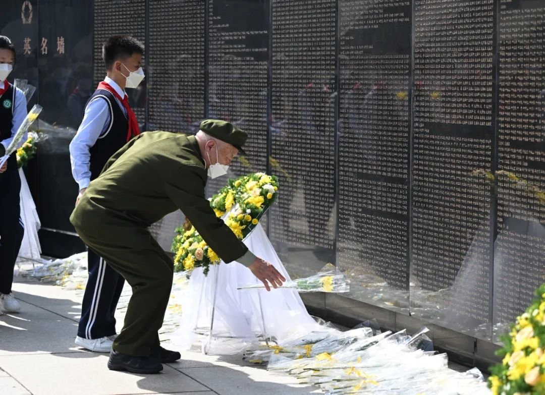 志愿军老兵向牺牲战友献花。