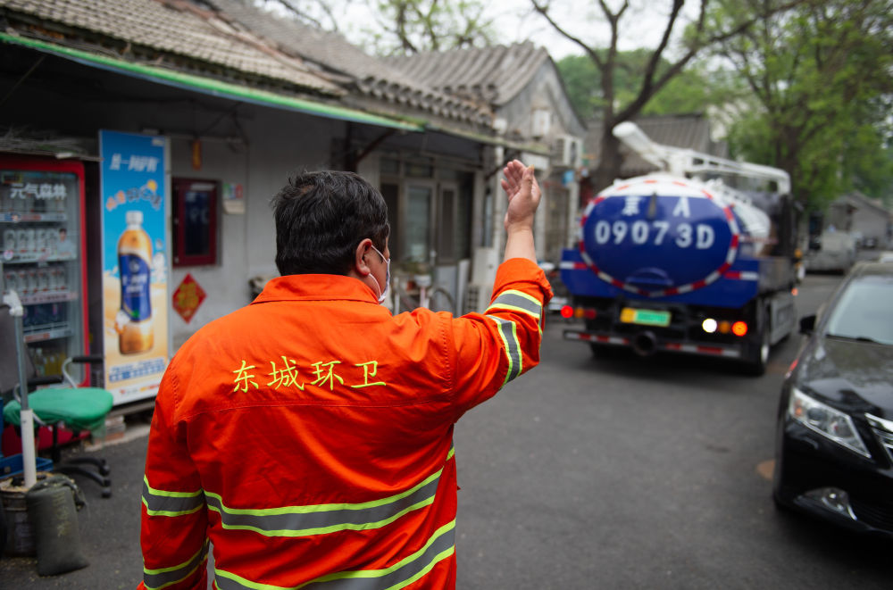 4月25日,北京市东城区的环卫工人引导孙志宝倒车进入公益巷胡同.