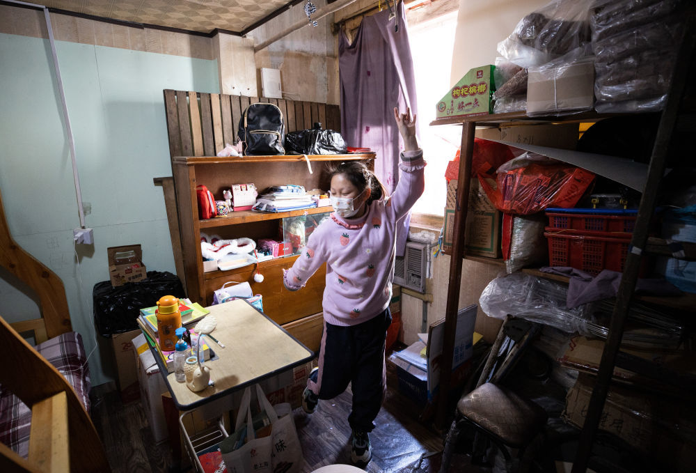 ↑4月8日,8户11人中唯一一名小学生龚悦在家中上体育课,按照老师要求模仿动物进行活动。