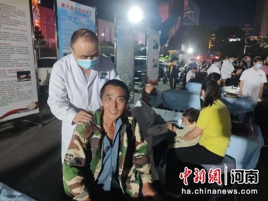 市民免费在唐河县“中医药文化夜市”上体验推拿按摩服务。王宇 摄