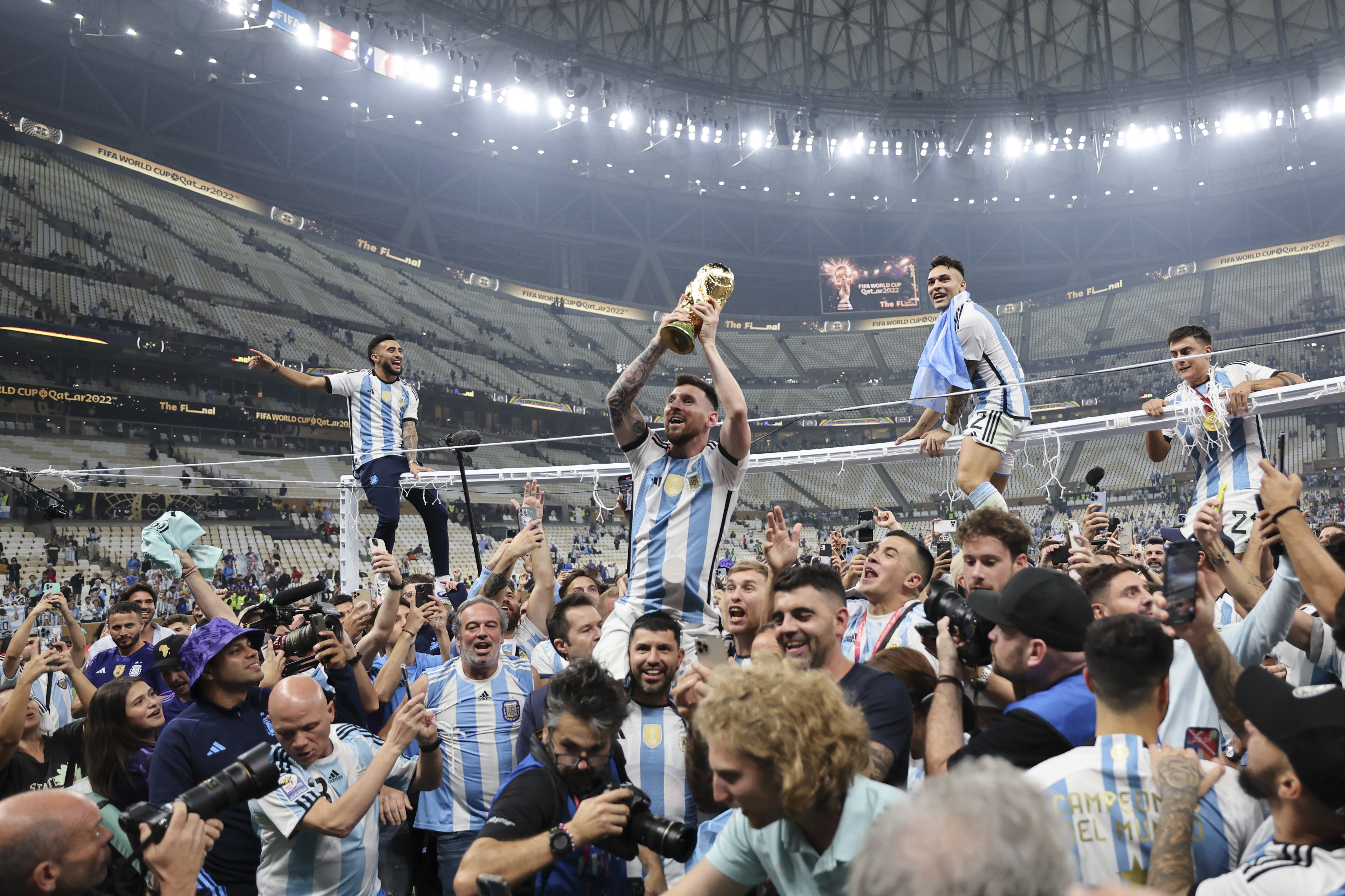 12月18日，阿根廷队球员梅西（上左二）在比赛后手捧大力神杯庆祝。新华社记者 曹灿 摄