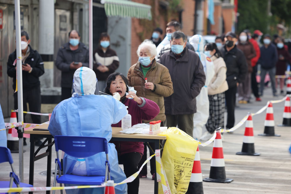 ↑4月1日,在上海市长宁区江苏路街道岐山居民区,工作人员为居民进行核酸采样。