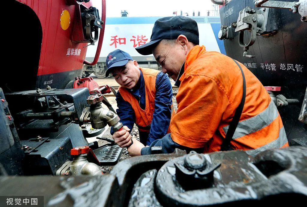 2022年2月7日，江西鹰潭，中国铁路南昌局集团公司鹰潭机务段整备车间交车工长聂华平（左）与工友一起更换机车风管。