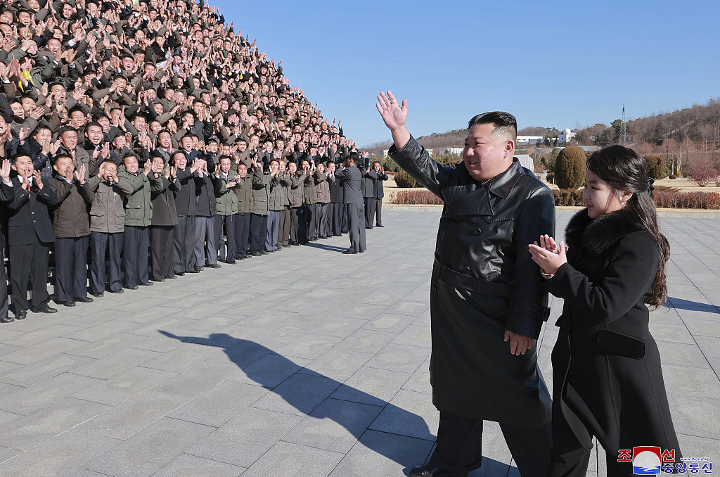 当地时间2022年11月27日，朝鲜领导人金正恩(中)和他的女儿(右)向参与“火星-17”洲际弹道导弹试射的科学家、技术人员、官员和其他工作人员挥手致意。人民视觉 图