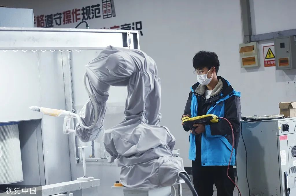 2022年2月7日，一位工程师在位于杭州萧山机器人小镇的车间调试智能喷涂机器人。