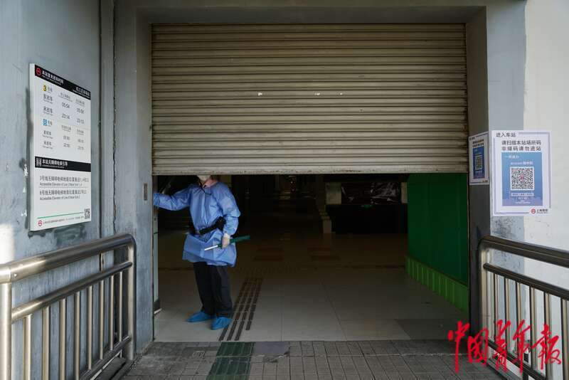 5月22日，上海地铁虹口足球场站，早上7点过后，一名地铁工作人员打开地铁入口的卷帘门。中青报·中青网记者 李强/摄
