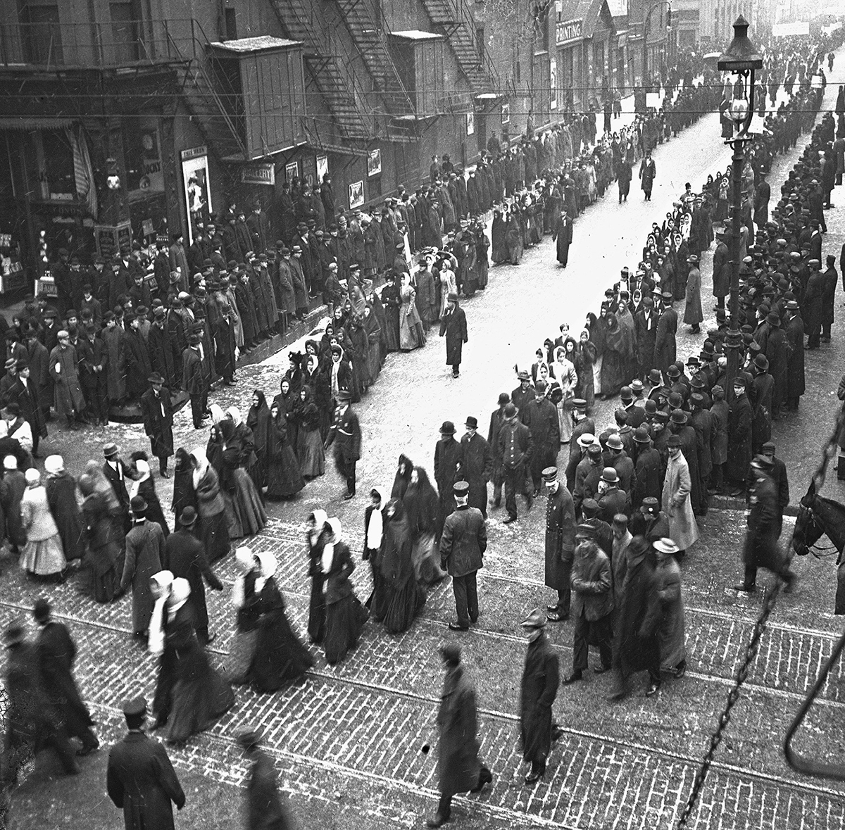 1909年3月8日，美国芝加哥的劳动妇女和全国纺织服装工业的女工举行罢工游行，一群男人和女人沿着西杰克逊大道游行。