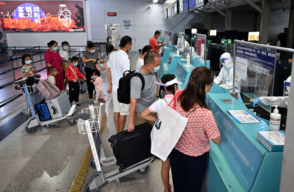 ↑8月9日，滞留三亚的游客在三亚凤凰国际机场办理登机手续。