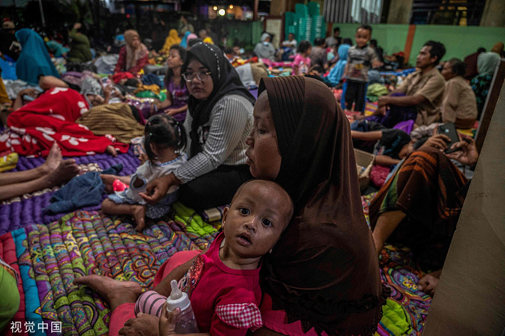 当地时间2022年12月4日，印度尼西亚东爪哇省，塞梅鲁火山喷发后，人们在坎迪普罗村一个社区大厅的房间里临时躲避。