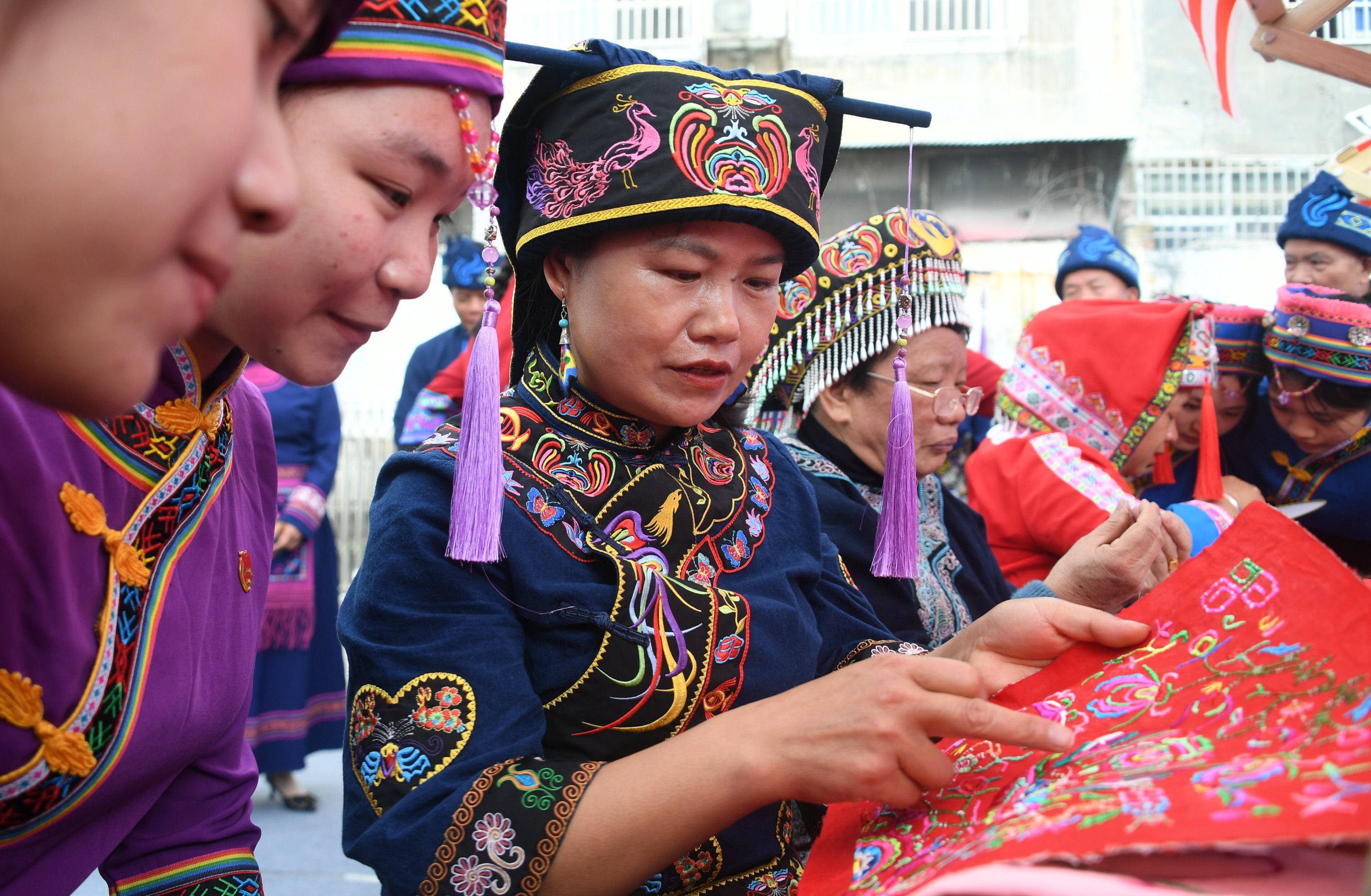 河池市罗城仫佬族自治县融媒体中心,仫佬族群众在展示仫佬族刺绣作品