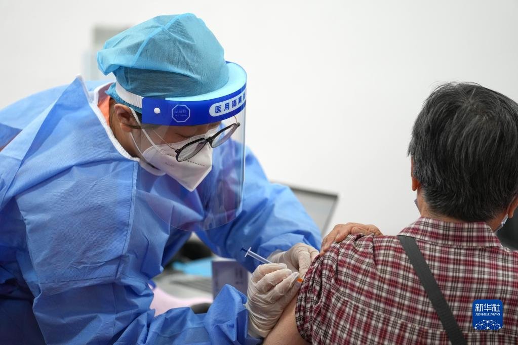 在北京市朝阳区奥运村街道一处新冠疫苗接种点，医护人员为一市民接种新冠疫苗加强针（2022年7月13日摄）。新华社记者 鞠焕宗 摄