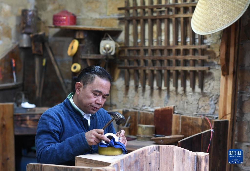 在贵州省黔东南苗族侗族自治州丹寨县卡拉村,银饰锻造技艺传承人王国春在锻造银制器具(11月16日摄)。新华社记者 杨文斌 摄