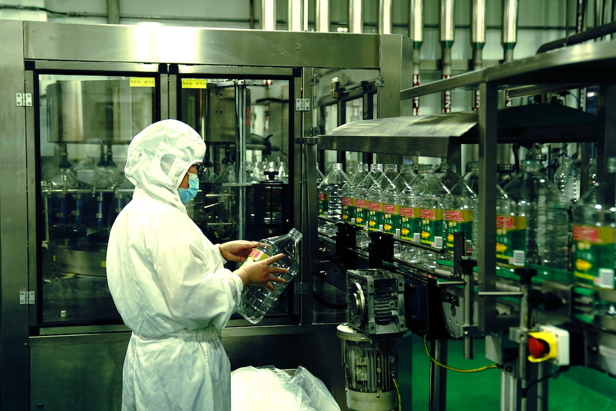 2022年4月22日，在上海嘉里食品工业有限公司的生产车间，操作人员抽检空油瓶贴标质量。