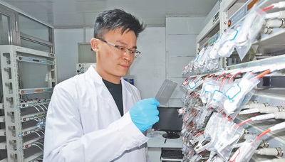 电池实验室里，王家钧正在进行电池测试研究。本报记者 张艺开摄