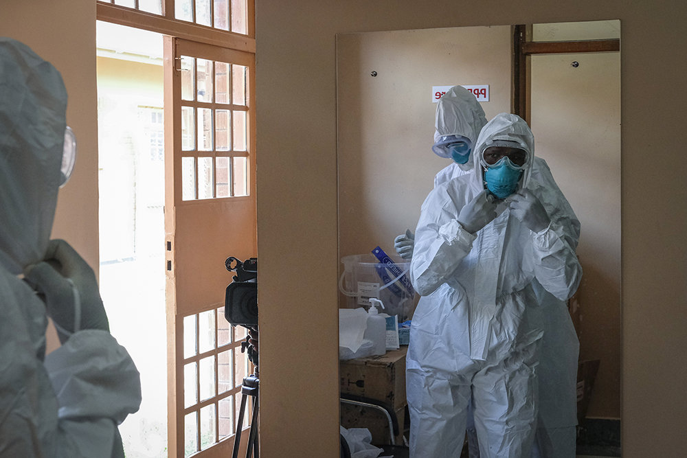 当地时间2022年10月20日，乌干达恩德培，在当地转诊医院的隔离病房，医生们穿上防护装备，准备去探望一名与埃博拉患者有过接触的人员。 视觉中国 图