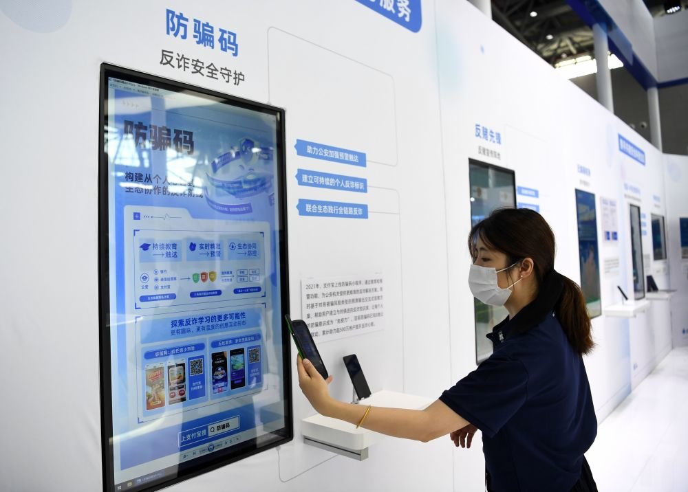 ↑9月4日，一家参展企业代表在演示使用防骗码。