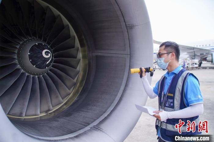 图为航线维护工程师对飞机发动机进行检查。 陈冠言 摄