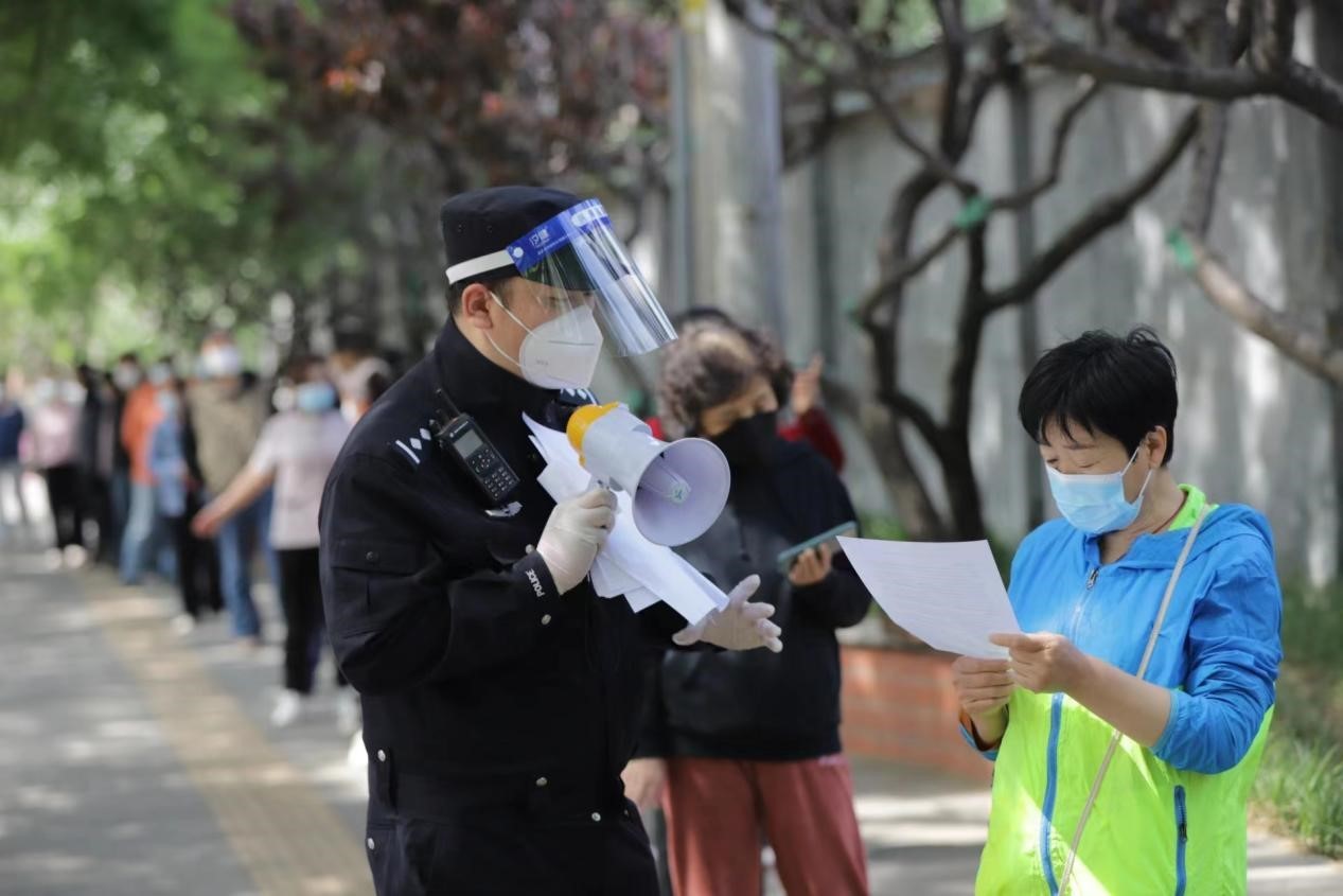 民警在维护秩序的同时开展反诈宣传.海淀公安分局供图