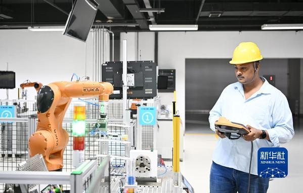 韩士兰在天津职业技术师范大学操作机器人设备（7月29日摄）。新华社记者李然摄