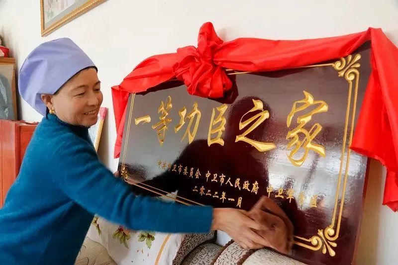 △母亲骄傲地擦拭牌匾