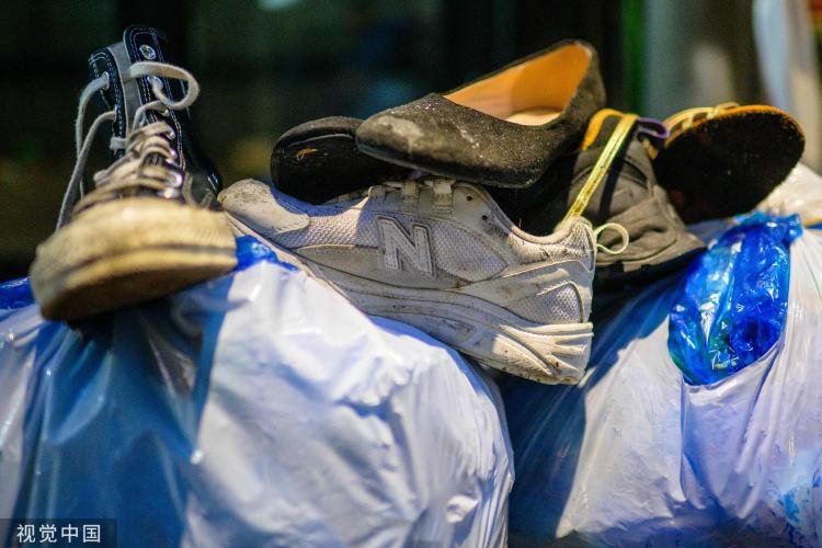 梨泰院踩踏事故现场，掉落的鞋子堆放在塑料袋上。/视觉中国