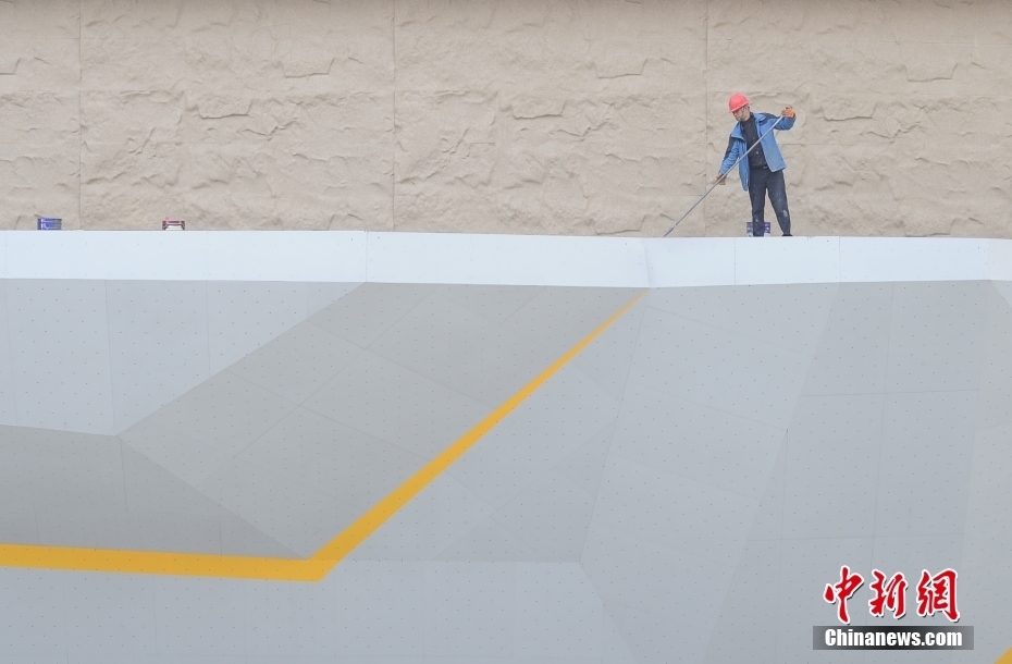 工人在羊山攀岩中心攀岩赛道上进行收尾施工作业。中新社记者 王刚 摄