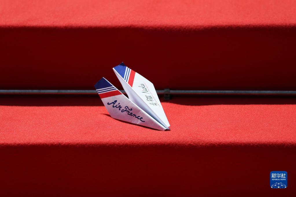 一只由打扮成小尼古拉模样的小学生扔出的纸飞机落在红毯上