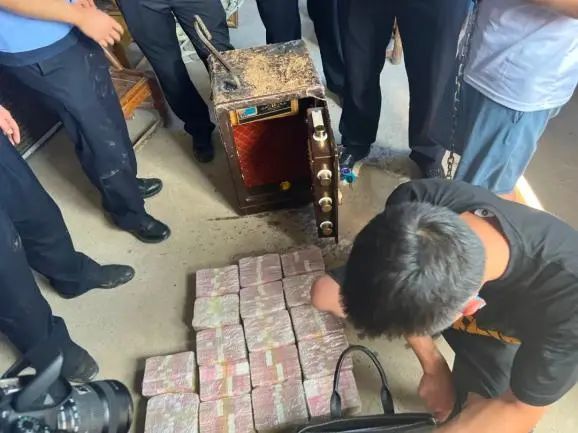 图为民警在嫌疑人家中猪圈内挖出藏有170万元赃款的保险柜。杨子仪 摄