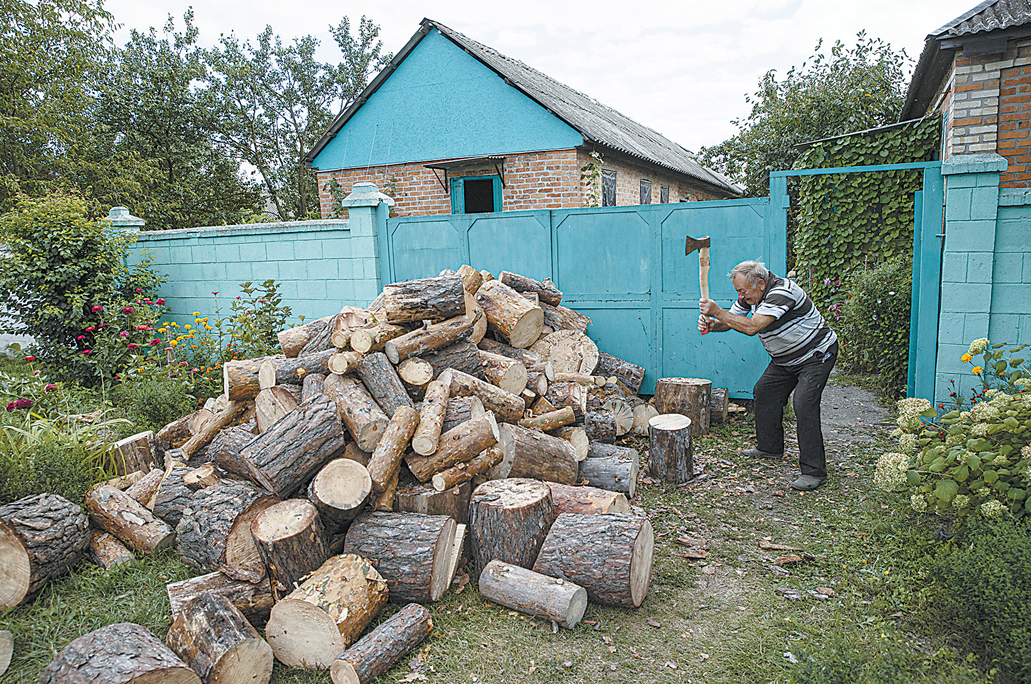 13日，乌克兰哈尔科夫一名男子正在劈柴为冬天做准备。（视觉中国）