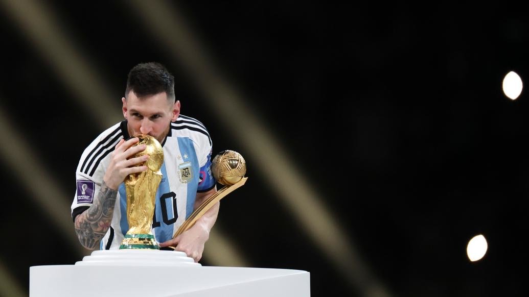 12月18日，获得世界杯金球奖的阿根廷队球员梅西在颁奖仪式上亲吻大力神杯。 新华社 图