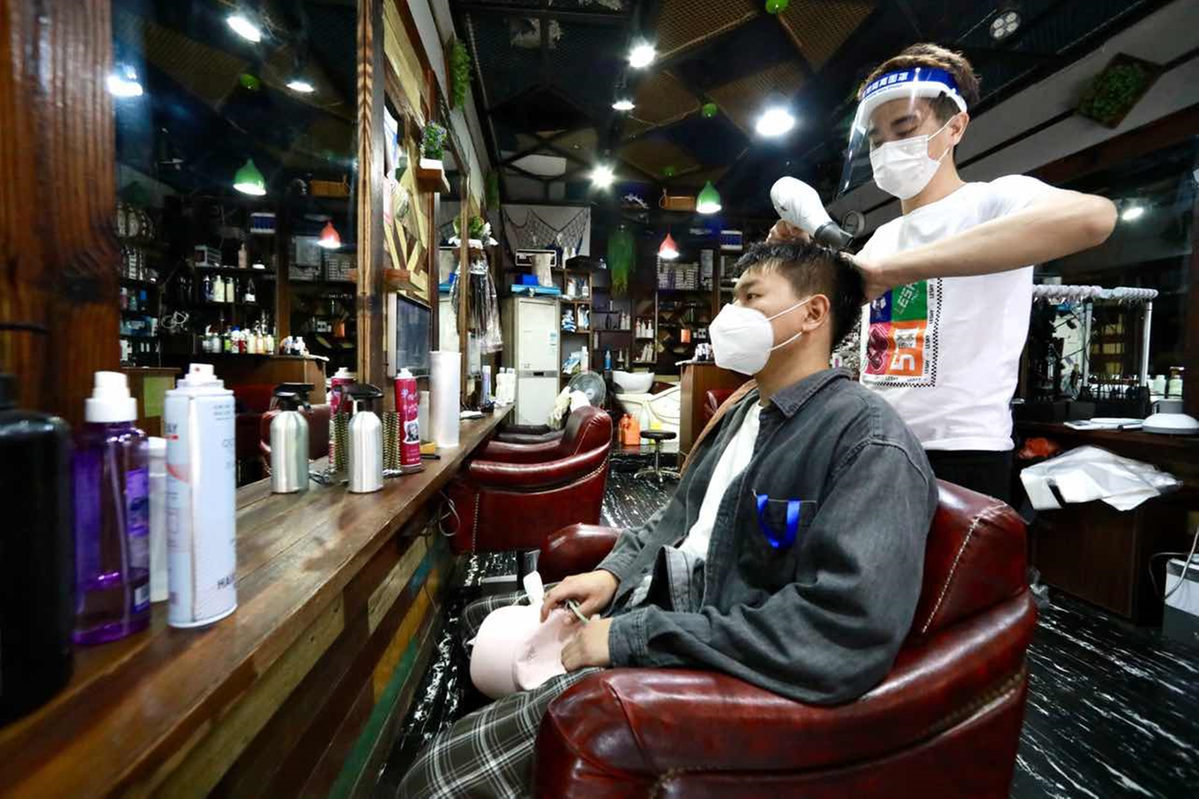 5月16日,在上海市金山区枫泾镇一家理发店,理发师为居民吹头发