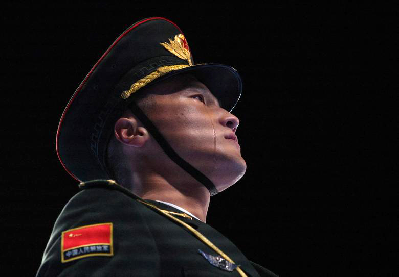 在升国旗仪式中，外媒记者抓拍到的一张中国军人的照片。