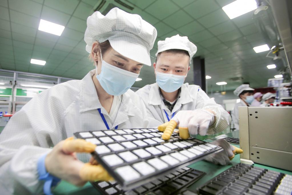 移柯智创厂房内,员工在对追踪器pt201机型外观以及产品进行检验.