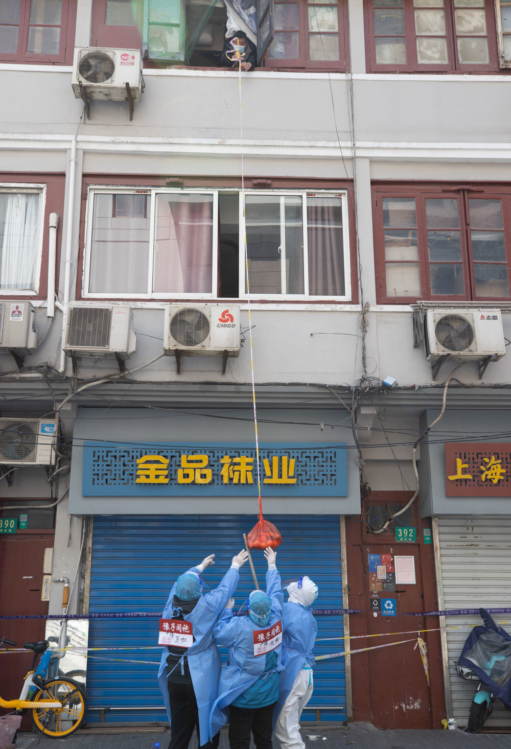 ↑4月3日,广福居委会工作人员王虹、陈艳、俞静芳(从左至右)在为居民金来根一家递送水果。