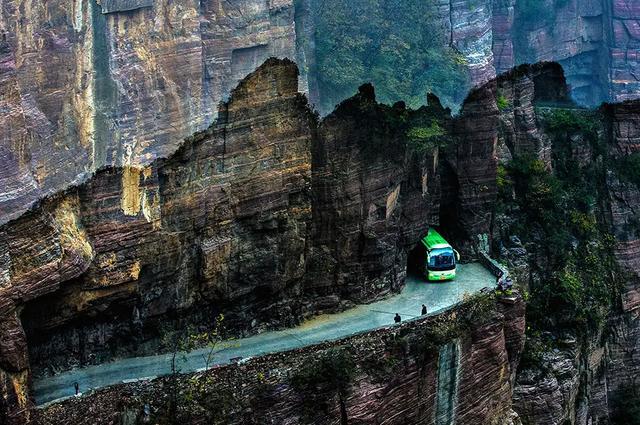 图为正在经过挂壁公路的大客车