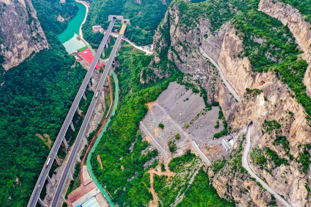 这是通过山西省长治市平顺县虹梯关乡的高速公路(画面左侧),一旁是过去的“挂壁公路”(画面右侧)(2022年7月5日摄,无人机照片)。新华社记者 曹阳 摄