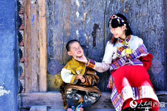 2022年5月，西藏迎来旅游旺季，游客身着藏装在八廓街拍照留念。人民网 李海霞 摄