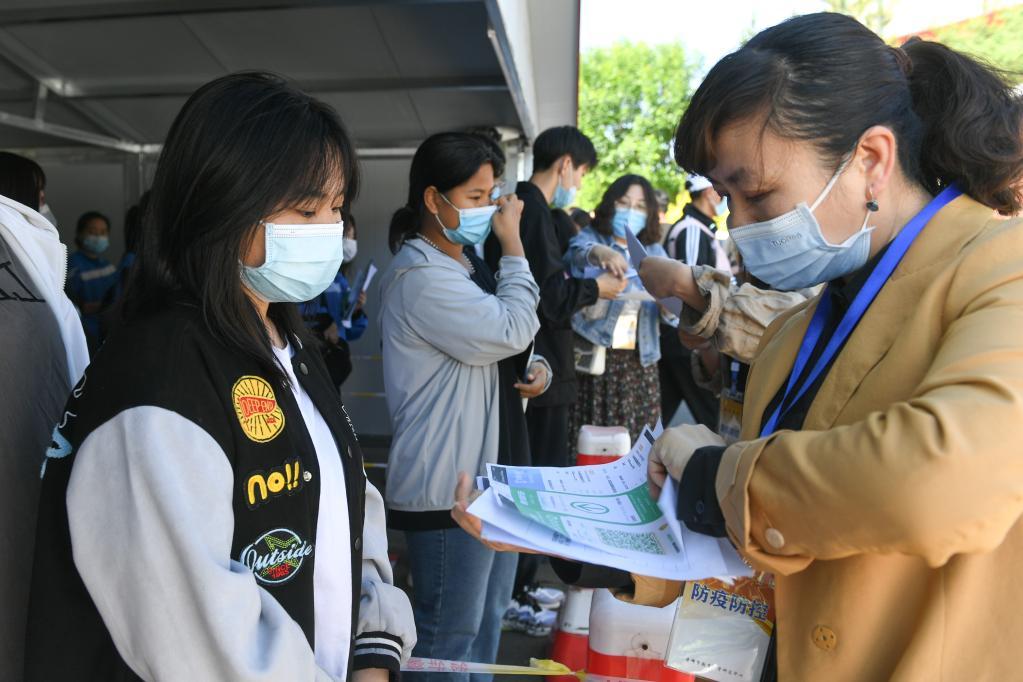 6月7日，在内蒙古赤峰市松山区第四中学考点，工作人员在检查考生健康码及核酸检测报告。（新华社记者 贝赫 摄）