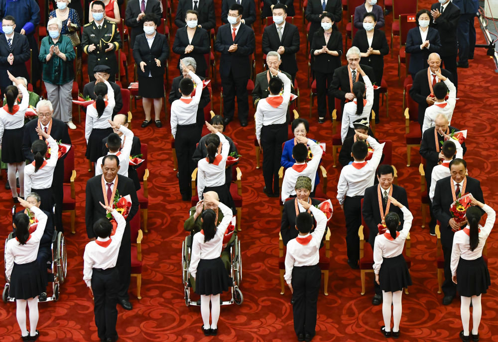 2021年6月29日，庆祝中国共产党成立100周年“七一勋章”颁授仪式在北京人民大会堂金色大厅隆重举行。这是少先队员向勋章获得者献花，敬礼致意。新华社记者高洁 摄